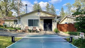 A residential house with a tennis court in front.