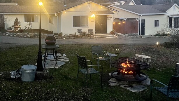 A residential property with a front yard, outdoor seating, and a fire pit.