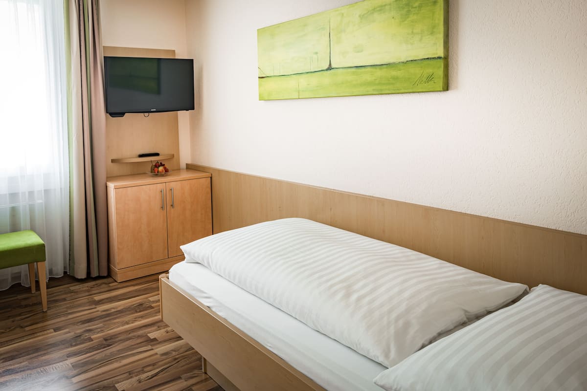 Standaard eenpersoonskamer | Een kluis op de kamer, een bureau, een laptopwerkplek