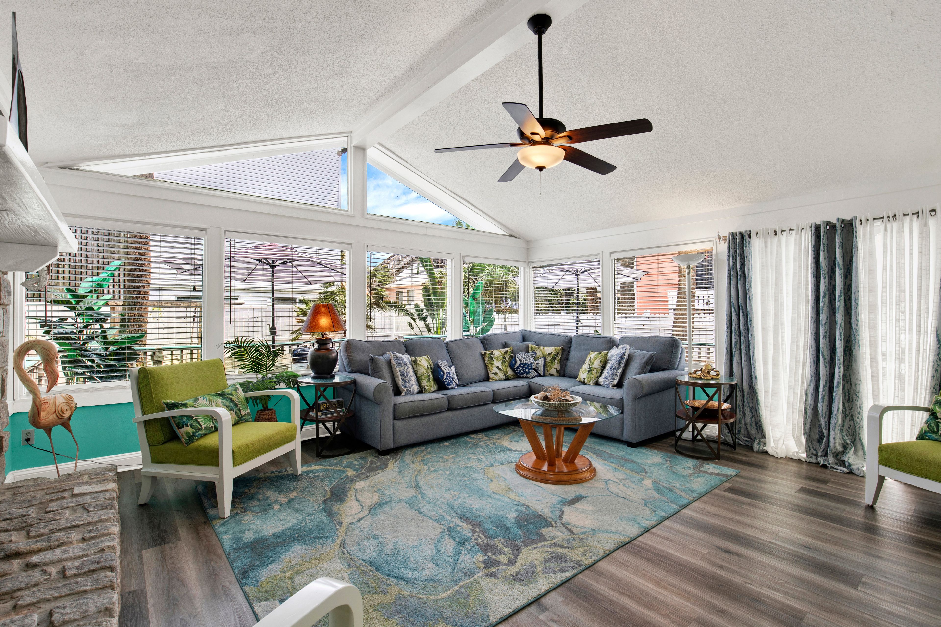 A spacious living room with a sectional sofa, a coffee table, and a ceiling fan.