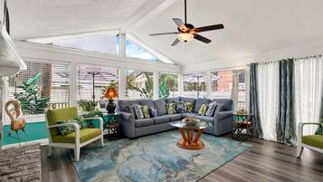 A spacious living room with a sectional sofa, a coffee table, and a ceiling fan.