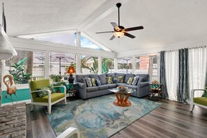 A spacious living room with a sectional sofa, a coffee table, and a ceiling fan.