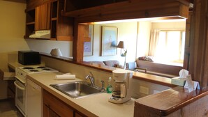 A kitchen with wooden cabinets, a sink, a stove, and a coffee maker. - MOOSE-WILSON ROAD- WILSON, WY- PERFECT LOCATION AND GREAT FAMILY RETREAT! (Wilson)