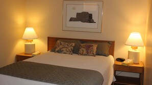 A neatly made bed with a quilted blanket, two bedside lamps, and a framed picture on the wall. - MOOSE-WILSON ROAD- WILSON, WY- PERFECT LOCATION AND GREAT FAMILY RETREAT! (Wilson)