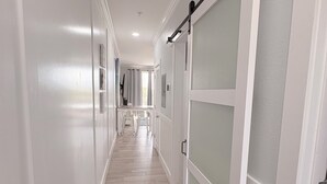 A hallway with a sliding door, a rug, and a ceiling light. - Coastal Condo with Amazing View & Beach Access (Santa Rosa Beach)