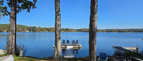 Une jetée au bord du lac, avec un canot et des chaises longues.