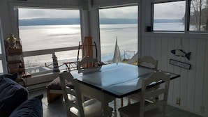 Un espace repas avec vue sur un lac, comprenant une table, des chaises et un banc.