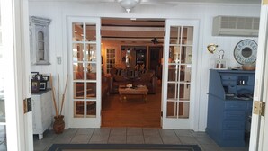 Une pièce avec un plancher en bois, un canapé en cuir marron, une table basse et un buffet bleu avec des tiroirs.