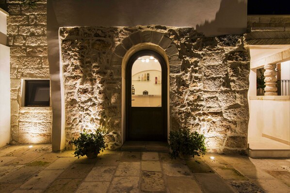 A stone archway leading to a building entrance at night.