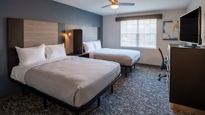 A hotel room with two beds, a desk, a chair, a ceiling fan, and a window with blinds. - Stay APT Suites Alexandria-Fort Belvoir (Alexandria)