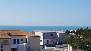 A coastal residential area with buildings featuring flat roofs and a clear view of the sea. - Appartement vue mer (Le Château-d'Olonne)