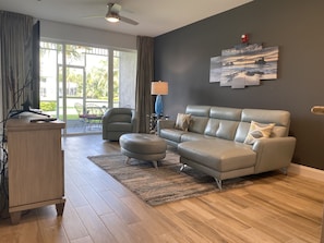 Relax in this stylish living room with a sofa, ottoman, and flat-screen TV.