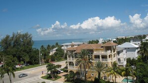 Zona residencial costera con un edificio grande que tiene balcones, piscina y vista al océano.