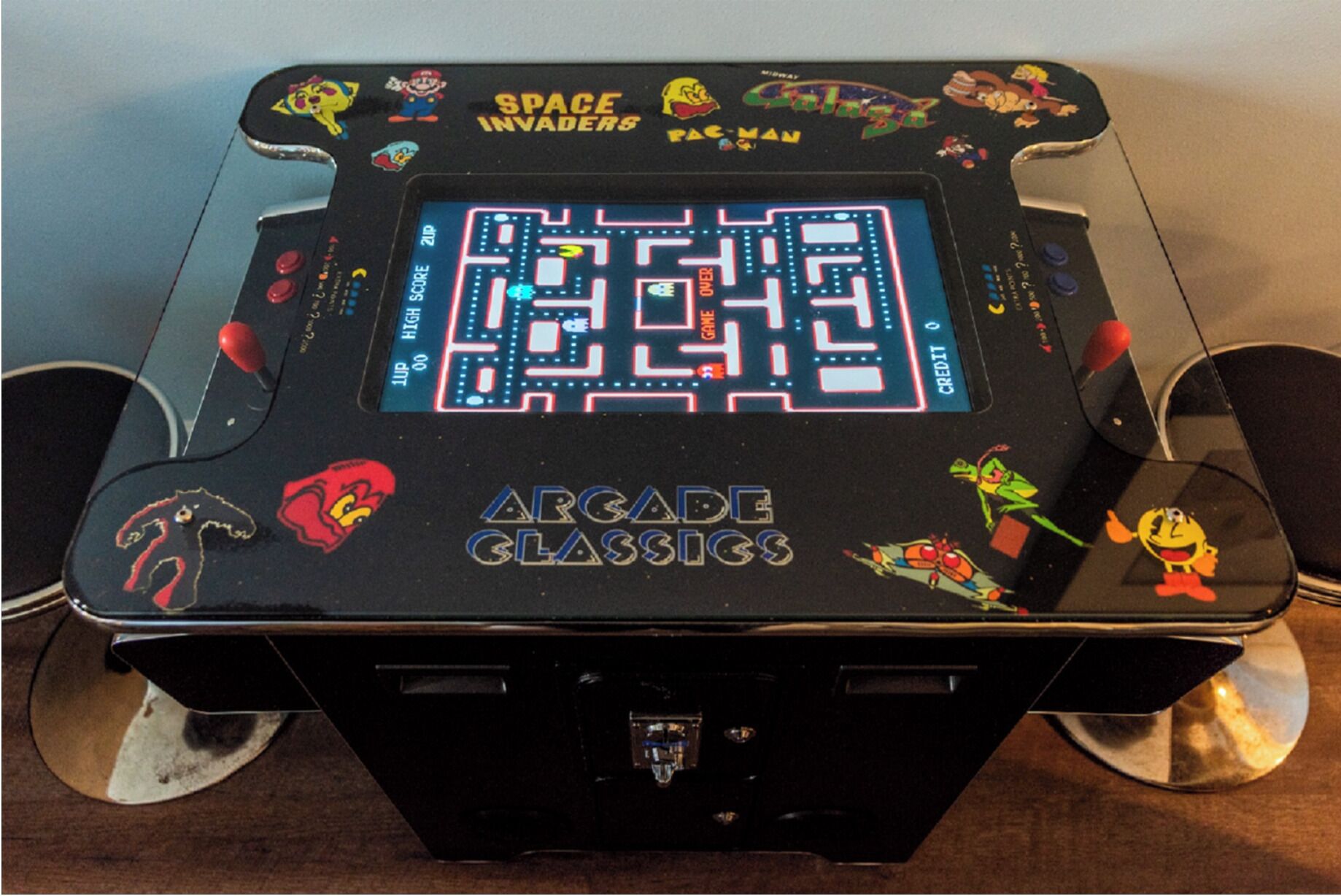 A retro arcade machine with a maze game, labeled 'Arcade Classics,' featuring characters from various games.