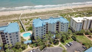 Hotel sulla spiaggia con diversi edifici, una piscina e vista mare.