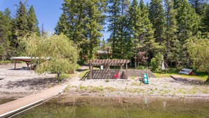 Ein Park am Flussufer mit einer Holzterrasse, Picknicktischen und einem Pavillon.