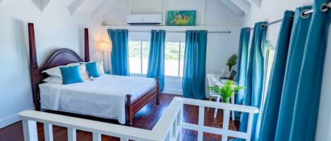 Un dormitorio con una cama de madera, cortinas azules, cabecera blanca y un tragaluz.