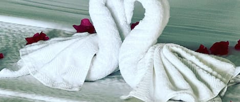 Una cama con un almohadón blanco y una manta.