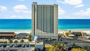 A tall hotel with a modern design, located near a beach with clear blue waters. - Sterling Breeze 203 - 1977174 (Panama City Beach)