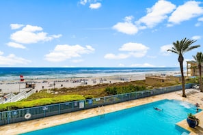 Zona de piscina amb vista a la platja i l'oceà.