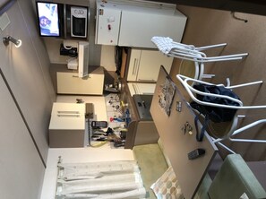 Cozy retreat with a kitchenette, featuring a TV, microwave, and refrigerator, plus a comfortable bed and seating area.