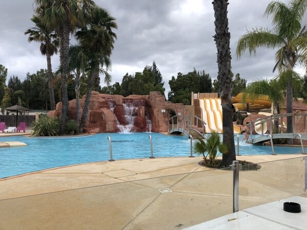 Relax by the resort's tranquil pool, surrounded by a naturalistic rock formation and a soothing waterfall.