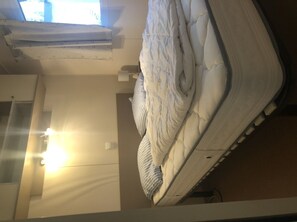Experience comfort in this serene space with a large plush mattress and simple, functional layout.