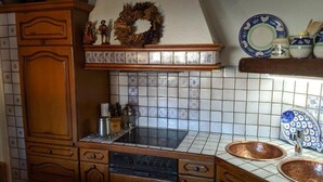 A kitchen with wooden cabinets, a tiled backsplash, a stove, and copper sinks. - Large apartment / TLA with 3 room-kitchen-bathroom, terrace and balcony (120m²) (Landstuhl)