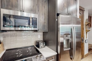 Enjoy cooking in this kitchen with stainless steel appliances, a microwave, toaster, and refrigerator with a water dispenser.