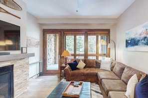 Relax in comfort on the large leather sofa, surrounded by a warm fireplace and natural views.