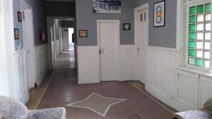 A hallway with a star-patterned floor, white doors, and framed pictures on the walls. - OYO Hotel Brás (São Paulo)