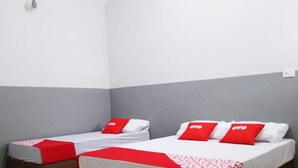 Two beds with red and white bedding, grey and white walls, and a visible electrical outlet. - OYO Hotel Brás (São Paulo)
