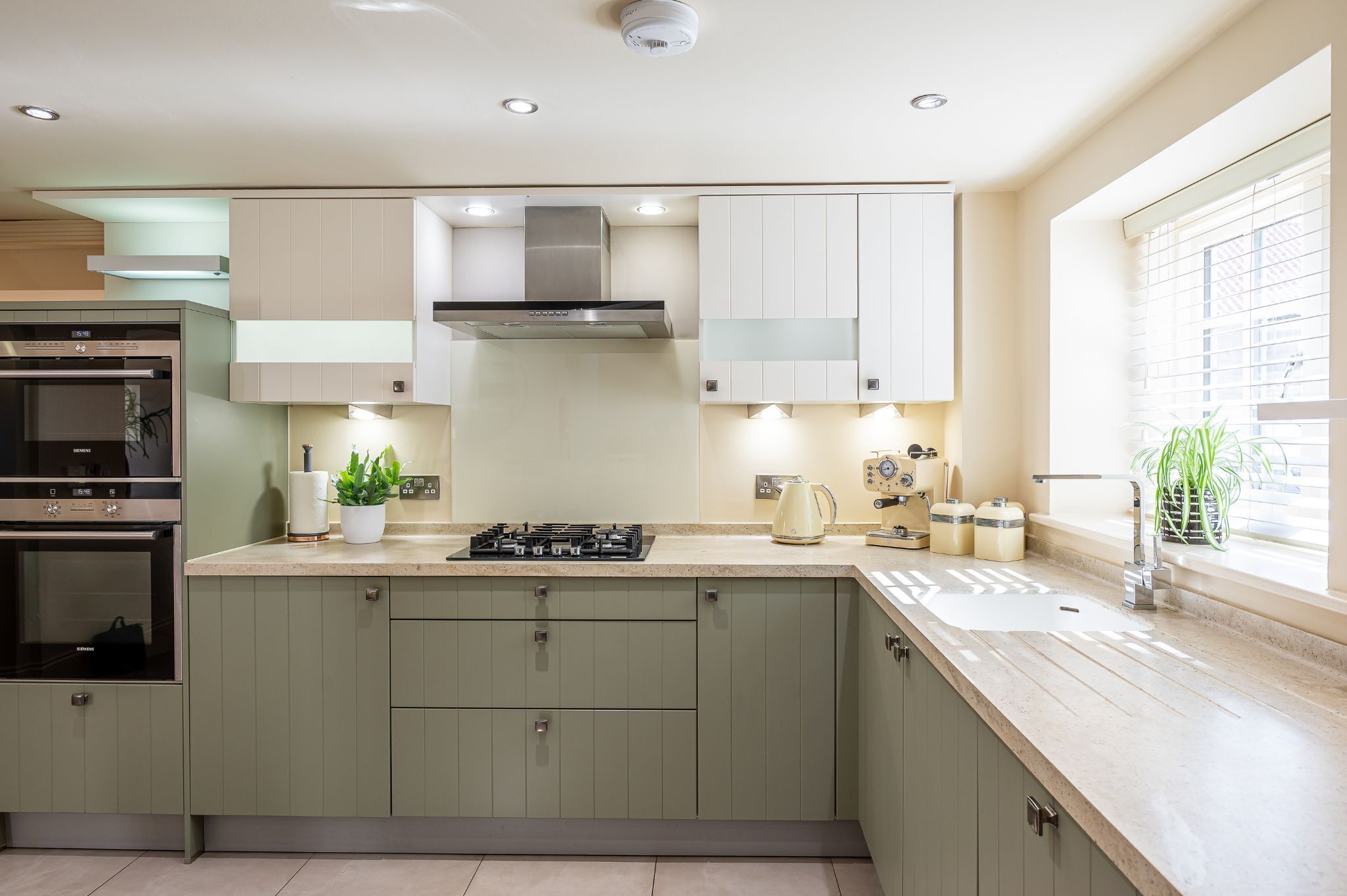 A modern kitchen with a built-in oven, a stove, and a range hood.