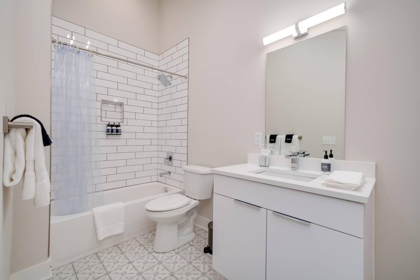 Une salle de bain moderne équipée d’une baignoire, de toilettes et d’un meuble-lavabo.