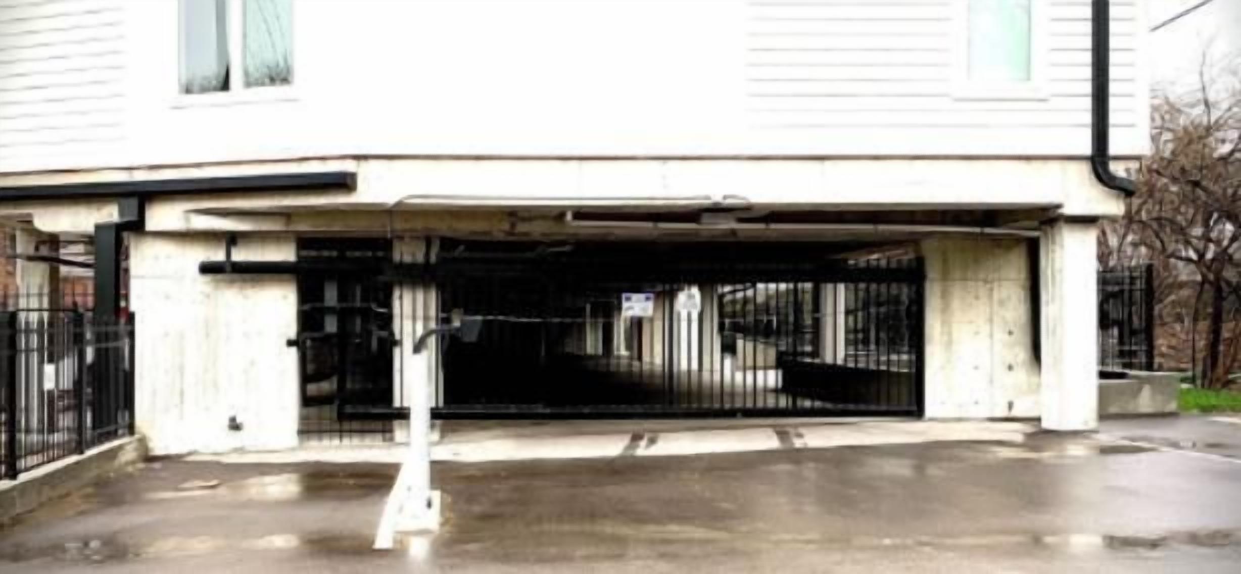 A gated parking area with a concrete structure and a metal gate.
