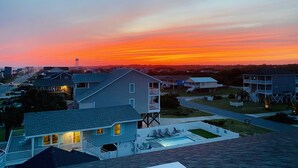 Una zona residencial con casas, una piscina y un atardecer.