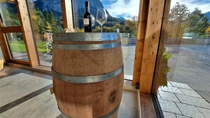 A wooden barrel in a room with large windows overlooking a mountainous landscape.