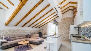 Una sala moderna con sofá, una mesa de centro y una zona de cocina con barra.