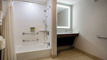 Un baño moderno con bañera, ducha y tocador con espejo.