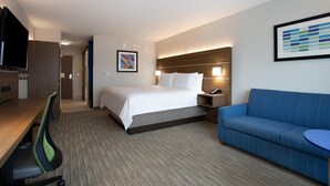 A hotel room with a bed, a desk with a chair, a sofa, and a TV. - Holiday Inn Express & Suites Deland South by IHG (DeLand)