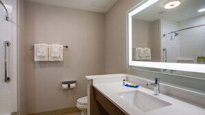 A modern bathroom with a white sink, a large mirror, and a shower area. - Holiday Inn Express & Suites Deland South by IHG (DeLand)