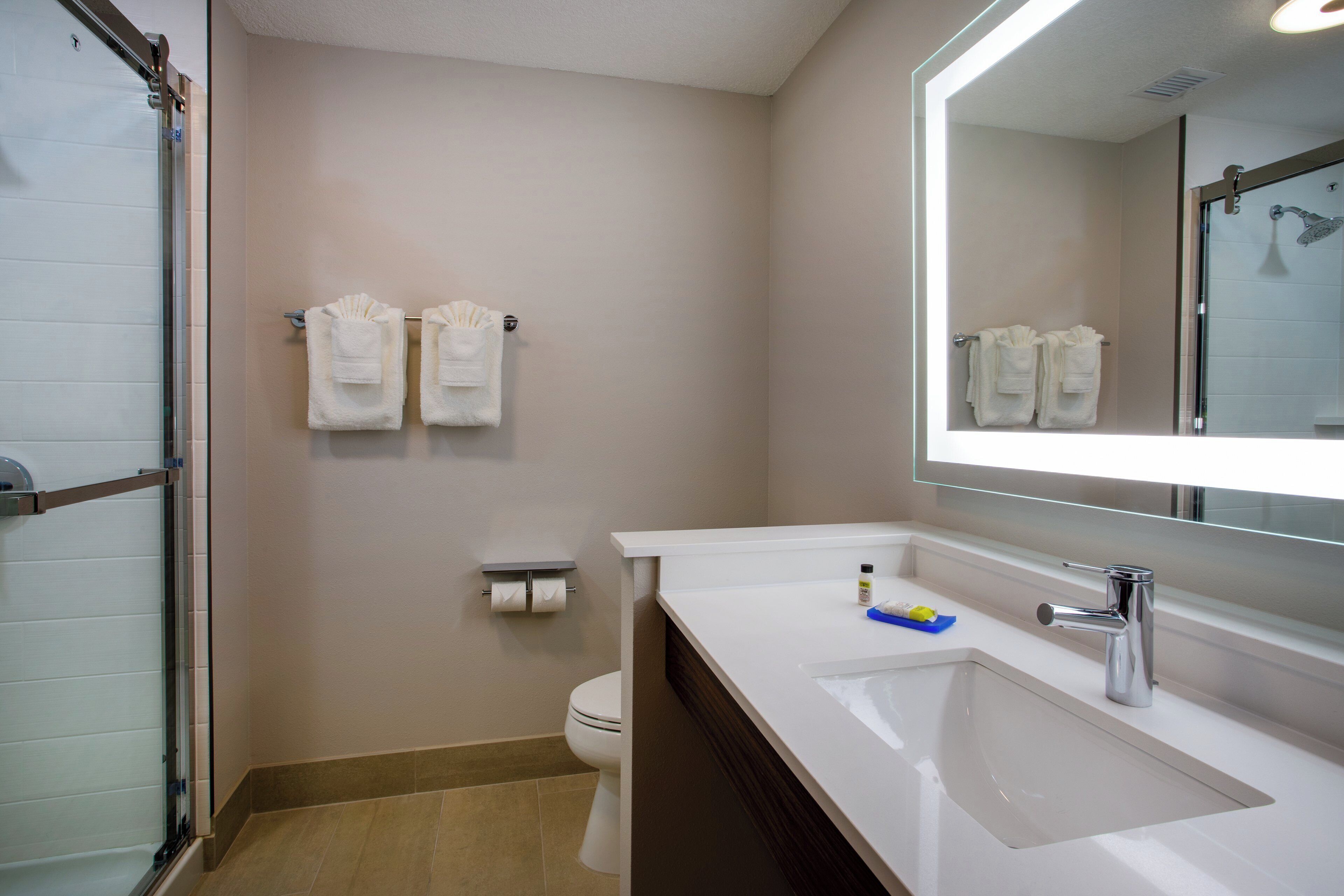 Une salle de bain équipée d’une douche, de toilettes, d’un lavabo et de serviettes.