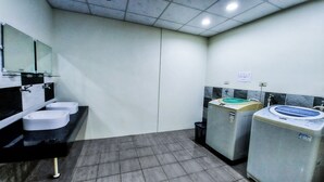 A public restroom with two sinks, a mirror, and two washing machines. - SUAO Backpackers (Suao)