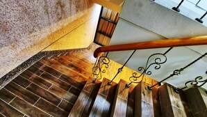 A wooden staircase with a metal railing and a view of the floor below. - SUAO Backpackers (Suao)
