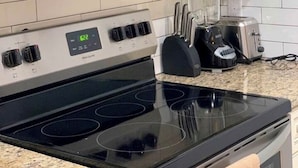 A kitchen with a stainless steel microwave, a built-in oven, and a toaster. - Comfort Zone Palace Inn (Jacksonville)