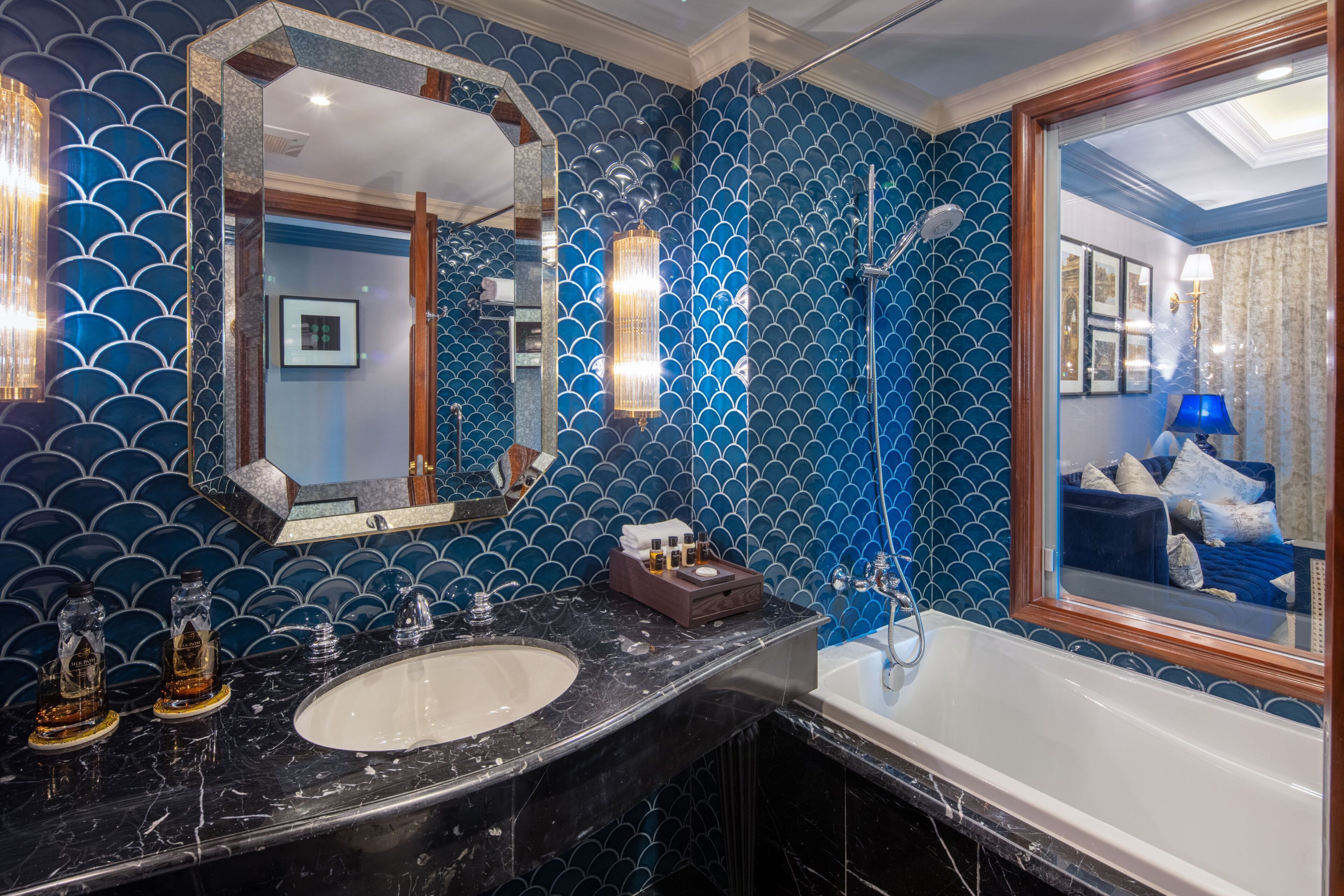 Une salle de bain avec un grand miroir, un lavabo et une baignoire.