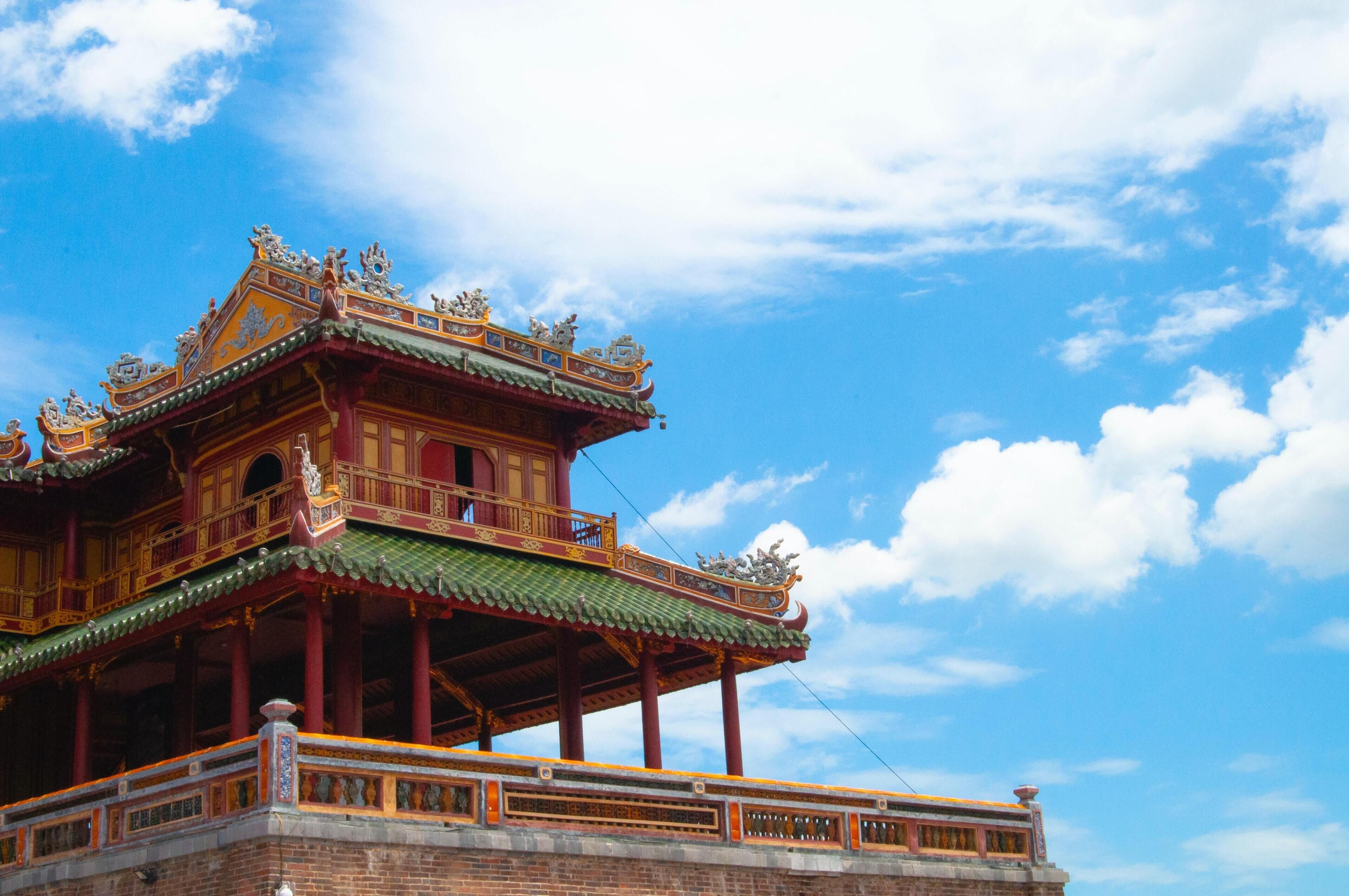 A traditional multi-tiered building with ornate decorations and a green roof.