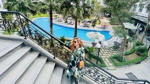 Una piscina al aire libre, sombrillas, sillones reclinables de piscina