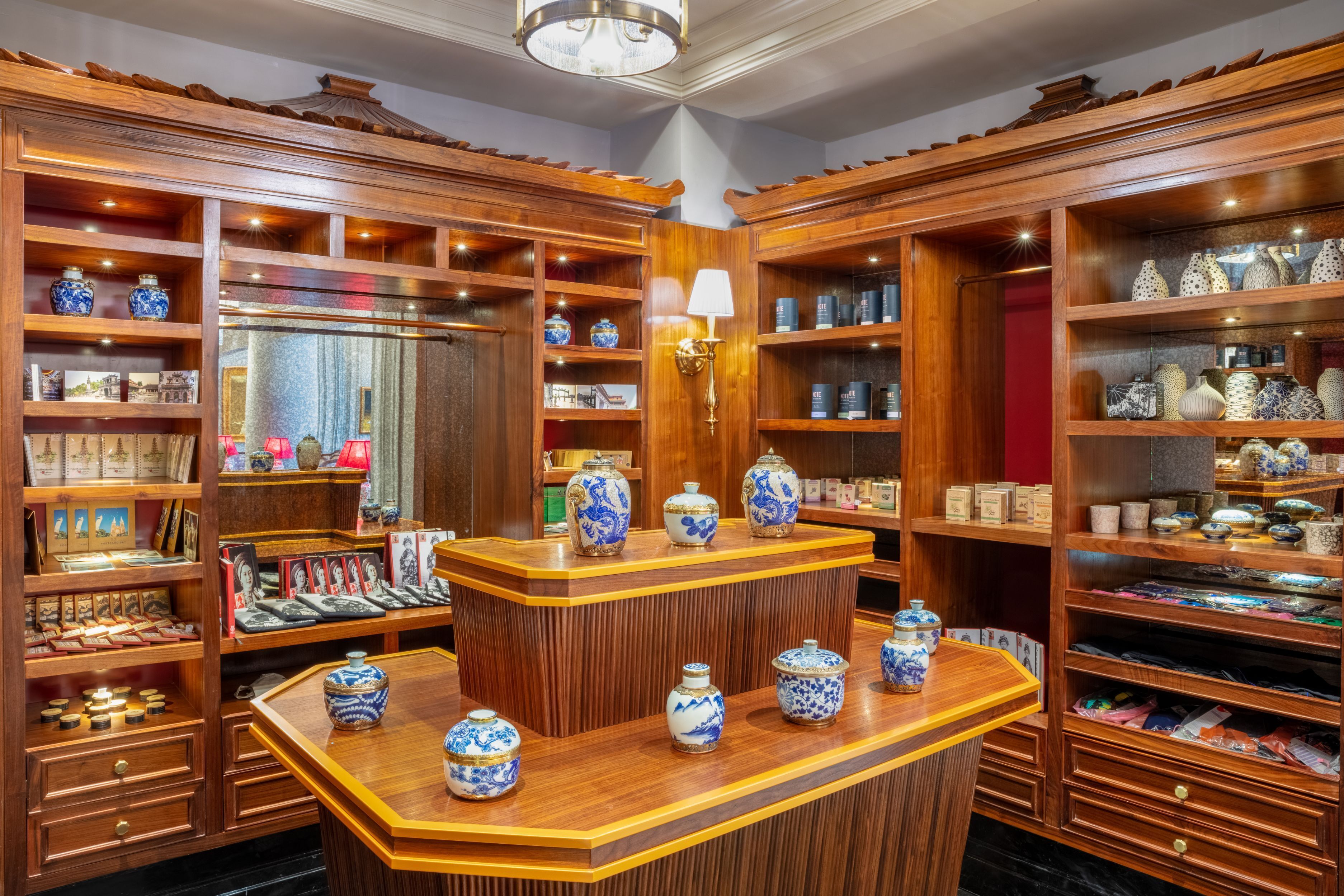 A traditional Chinese-style room with wooden shelves and a central wooden counter displaying blue and white porcelain vases.