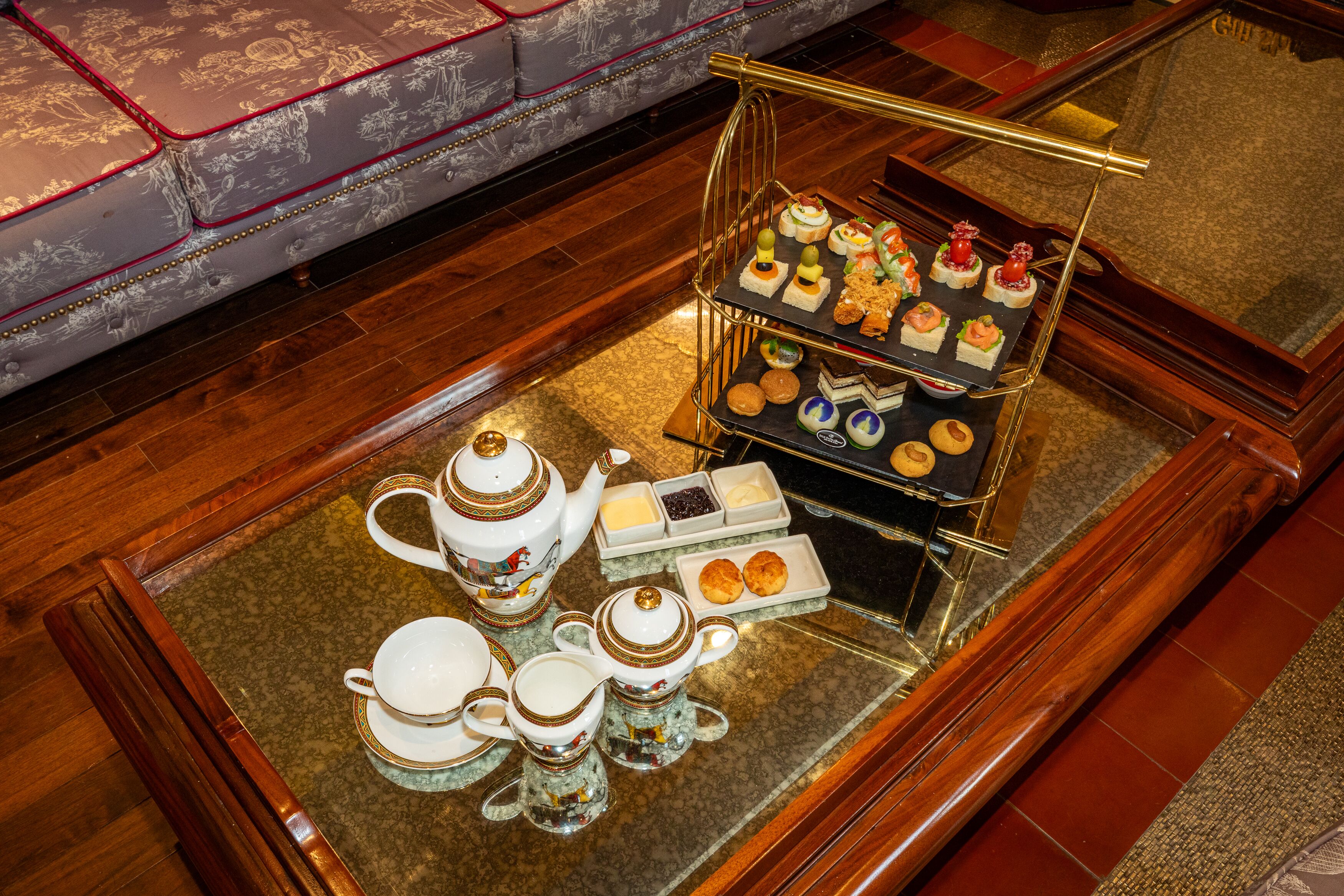 Un service à thé disposé sur un plateau, accompagné d’un assortiment de pâtisseries et de biscuits.